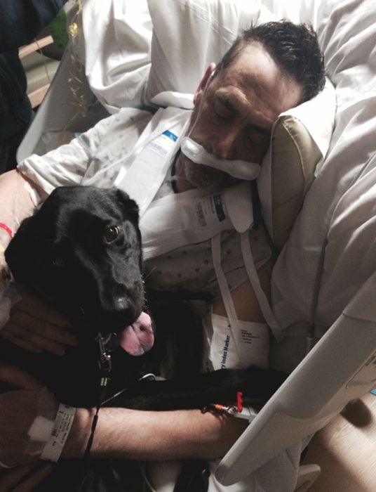 señor en el hospital con un perro negro