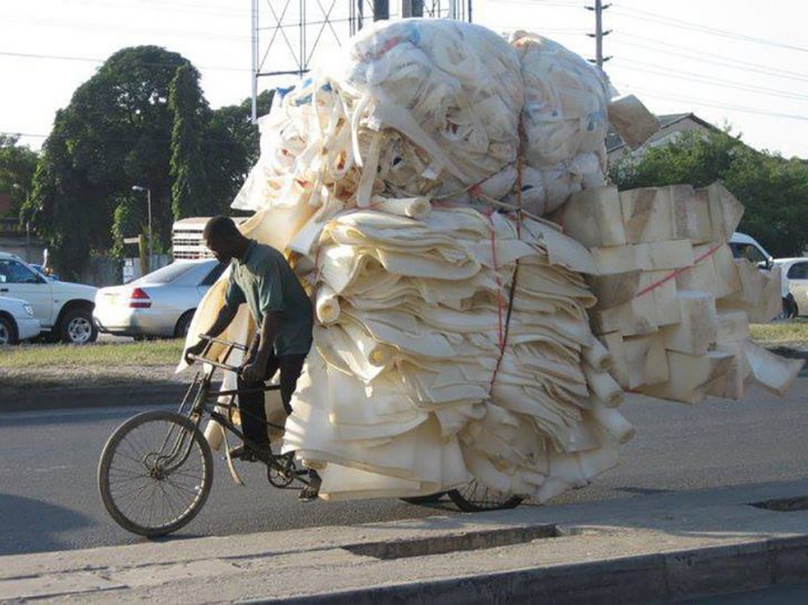 chico con una gran carga de esponjas en su bicicleta