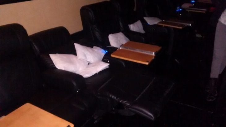 asiento con mesitas y almohadas en el cine 