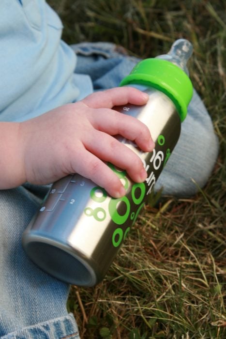 bebé sosteniendo un biberón ecológico 