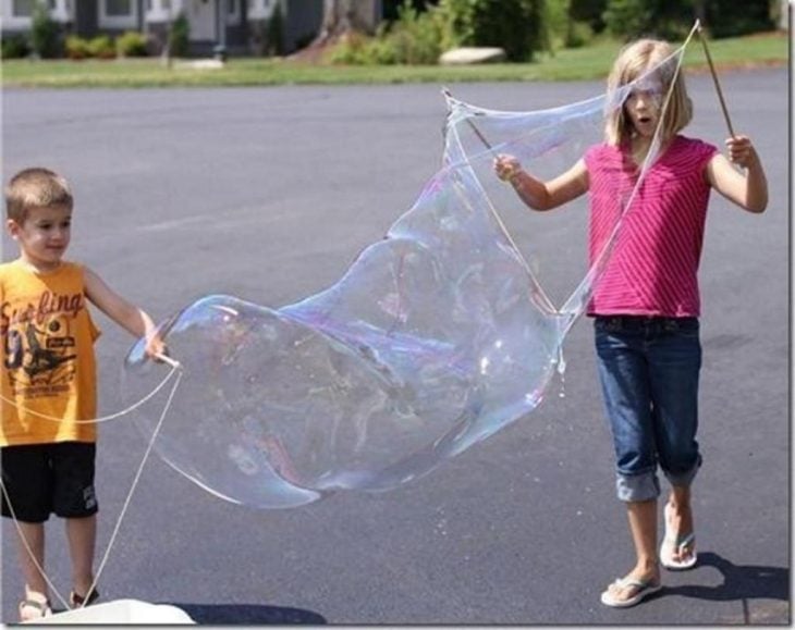 niños jugando con burbujas gigantes