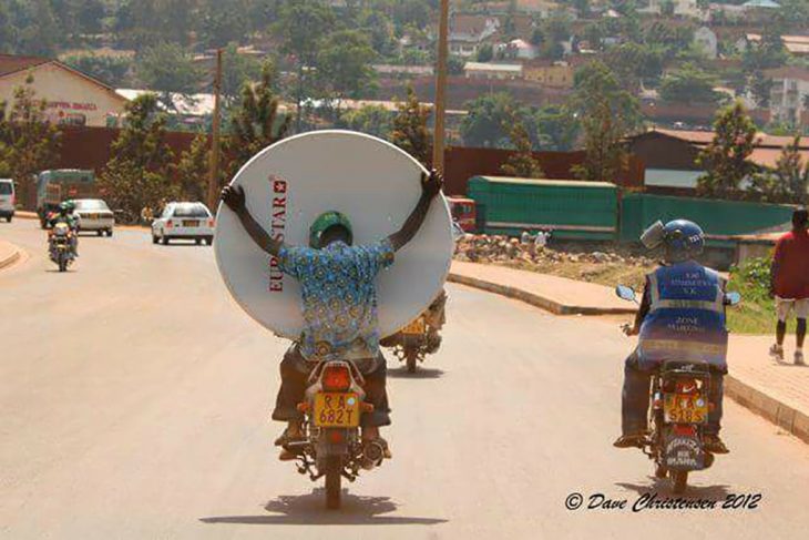 chico en moto con una antena televisiva 