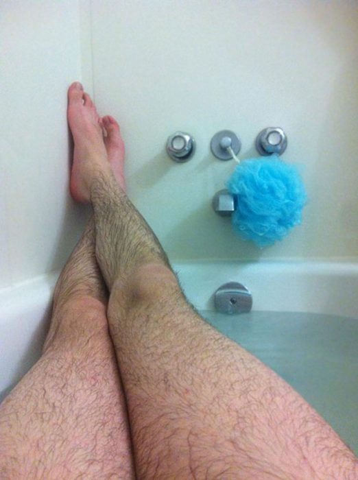 Piernas peludas de hombre en una bañera