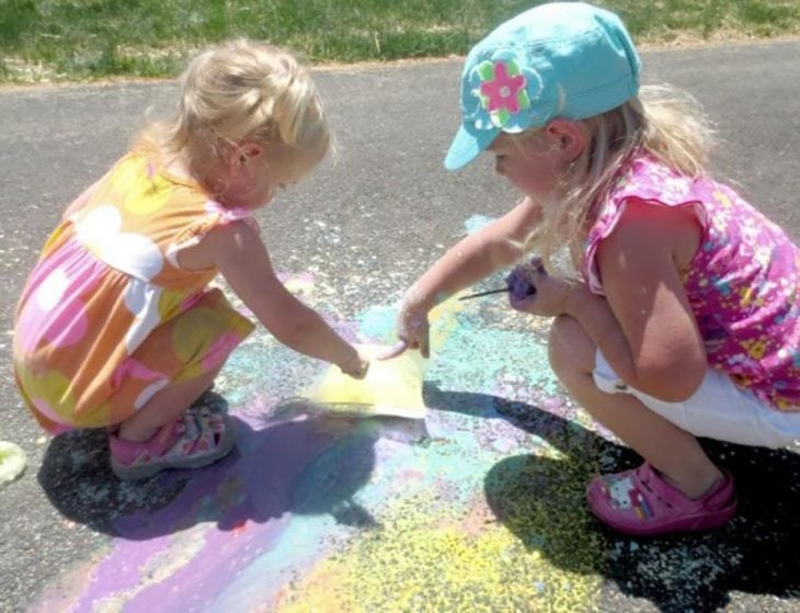 niñas explotando bolsas de pintura en el patio