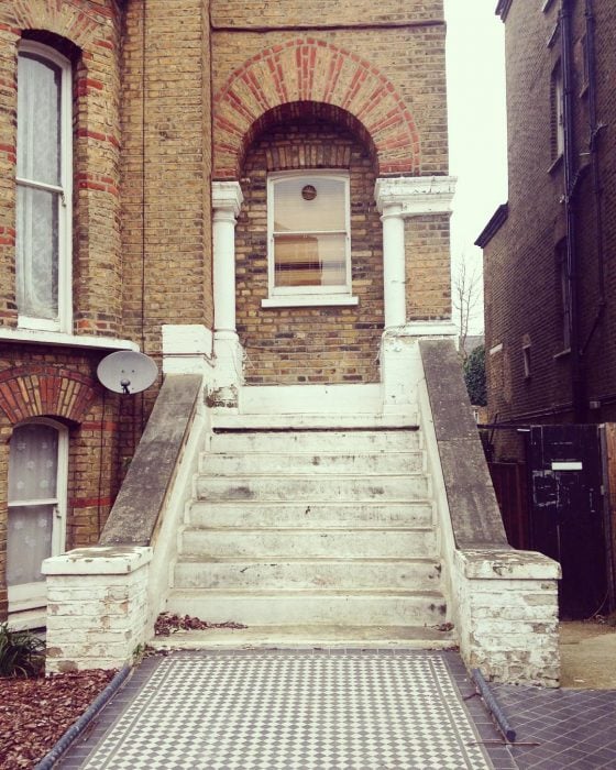 escalera a una ventana que está llena de ladrillos