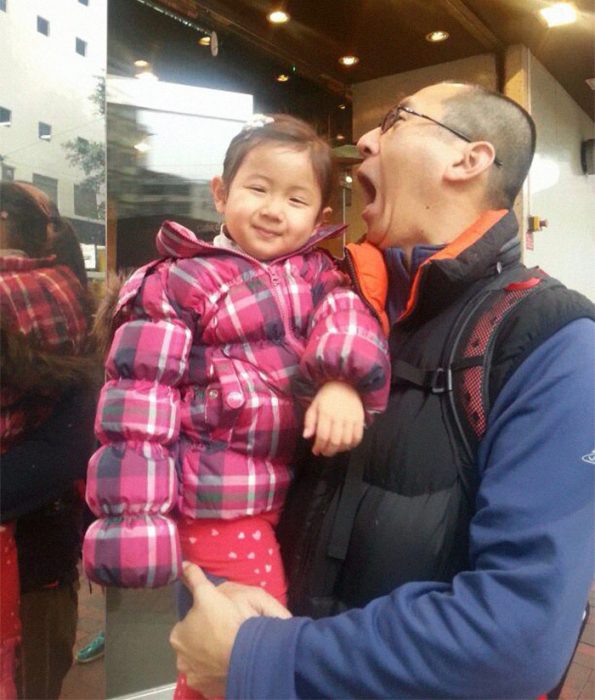 papá asiático cargando a su niña 