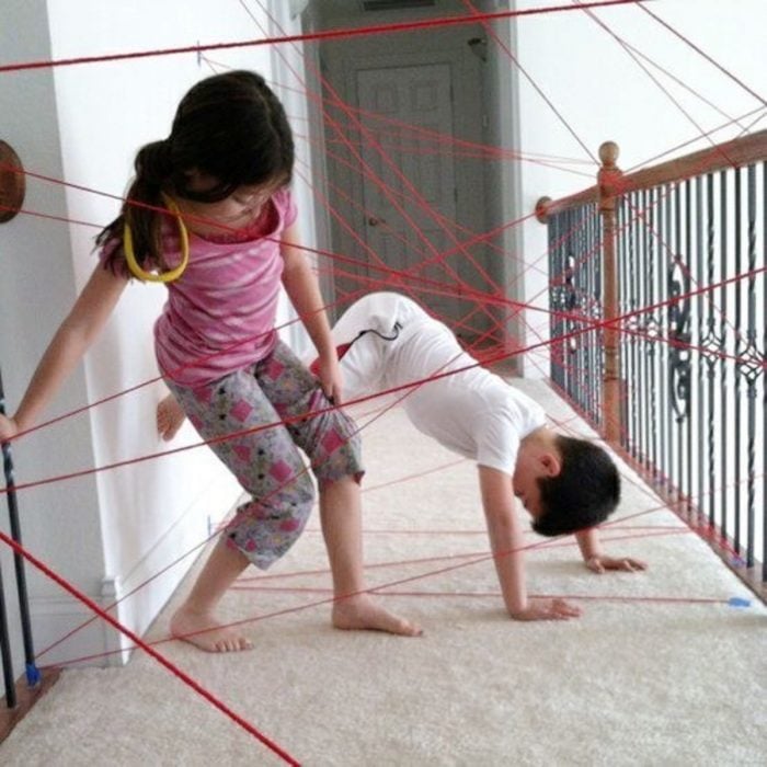 niños jugando en trampa láser de estambre