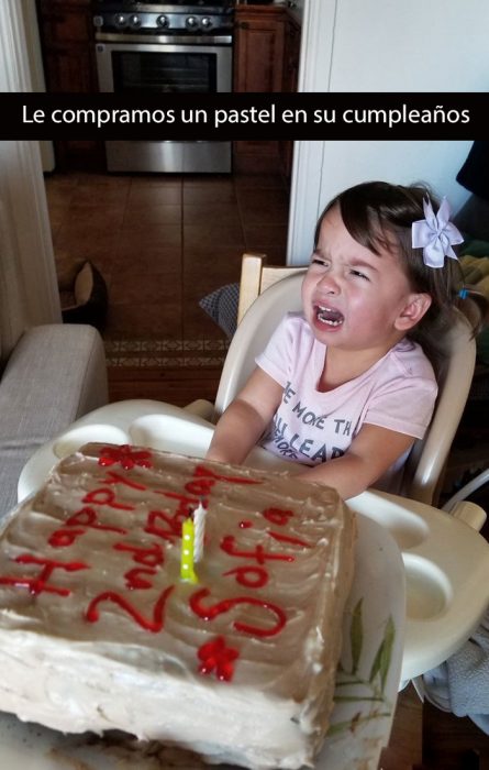 niña llorando frente a un pastel de cumpleaños