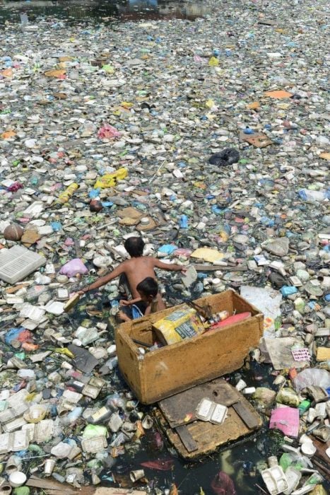 niños en un lago lleno de botellas