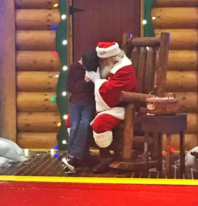 niño llorando al lado de santa claus