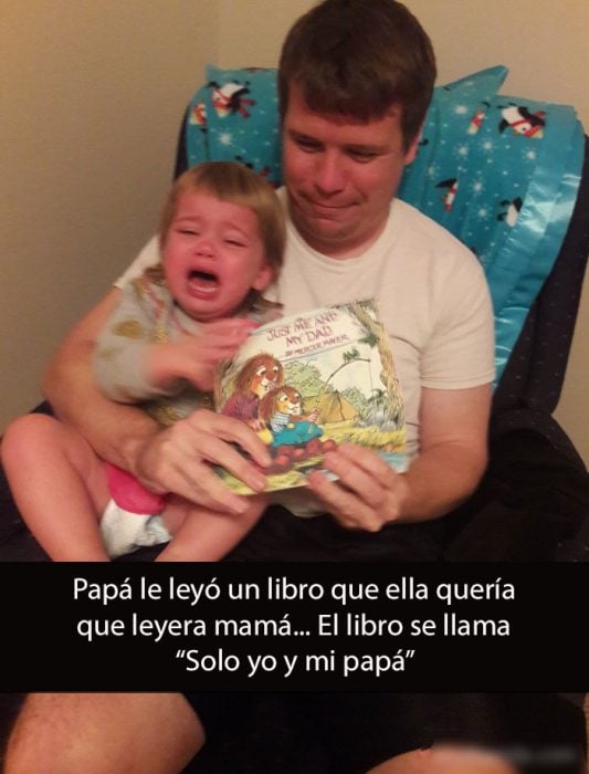 niña llorando en el regazo de su papá que le esta leyendo un libro