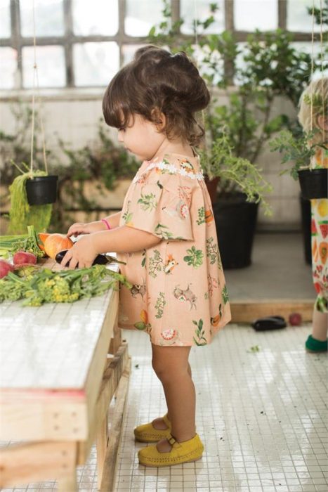 niña con un vestidito en un set con plantas