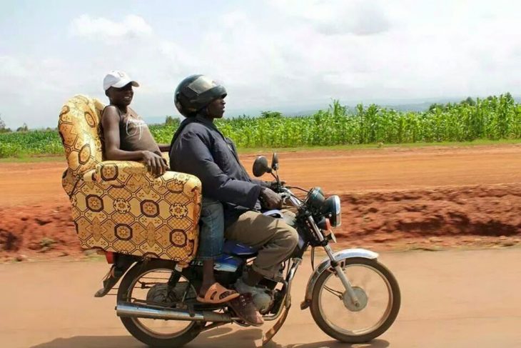 chavo en moto lleva a otro chavo en un sillón 