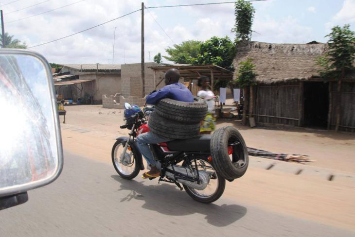 chavo en moto con llantas en su cintura