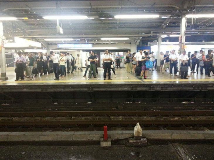 japoneses esperan en fila la llegada del tren