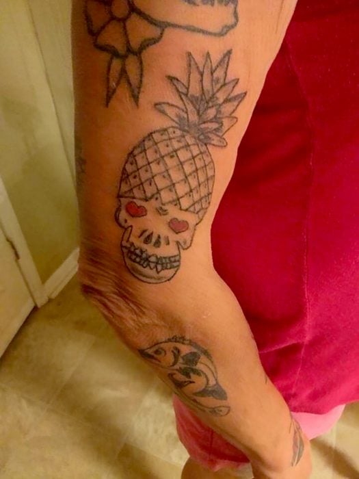 tatuaje de calavera con una piña en la cabeza 