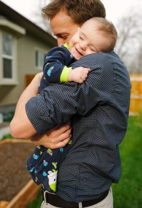 bebé sonriendo mientras abraza a su papá 