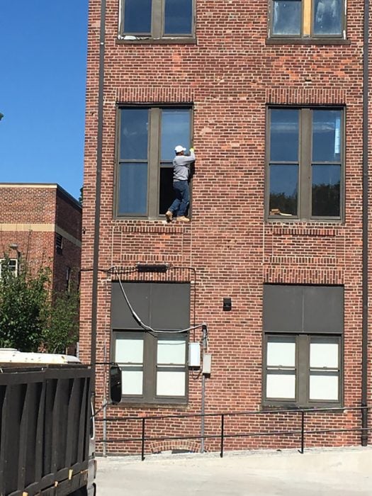 hombre en un edificio limpiando una ventana 
