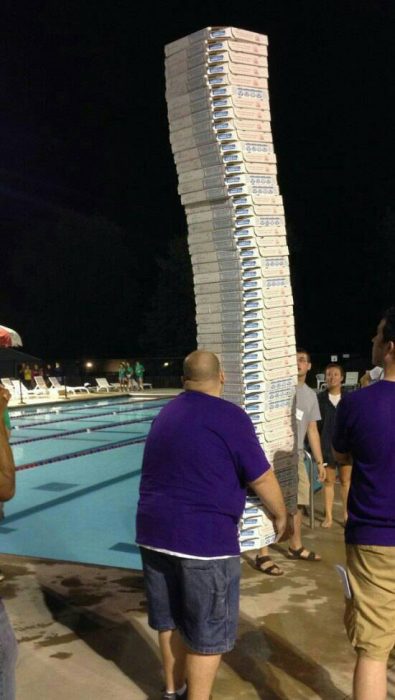 hombre cargando muchas pizzas 