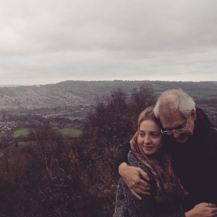 mujer abrazando a su padre con paisaje en el fondo 