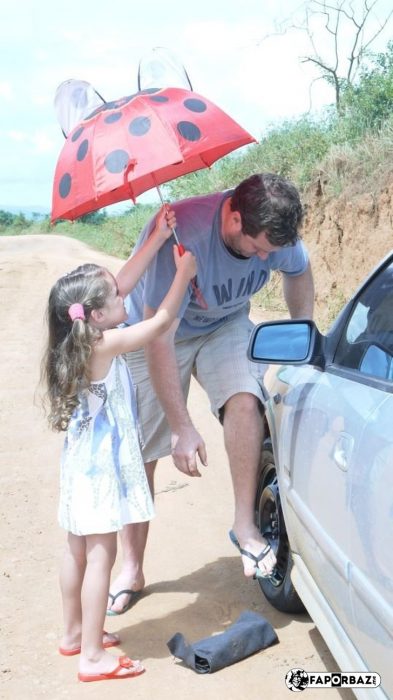 niña le pone sombrilla a su papá 