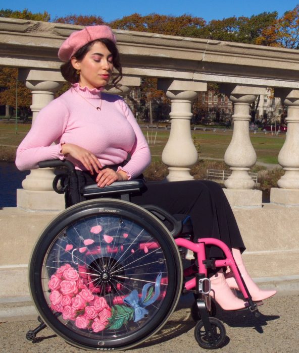 chica vestida de rosa con silla de ruedas decorada 