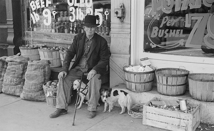  Un hombre y su perro frente a una tienda en Illinois, 1940