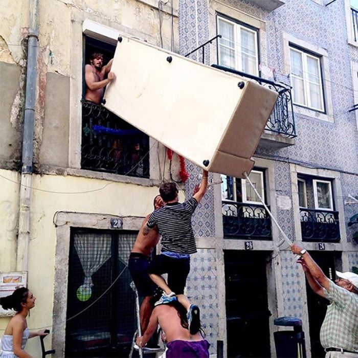 hombres sacando un refri por la ventana 