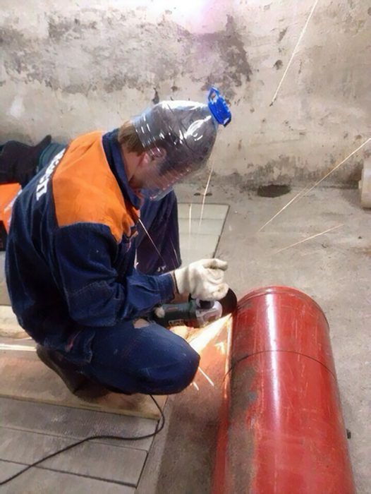 hombre con casco hecho de una botella soldando algo