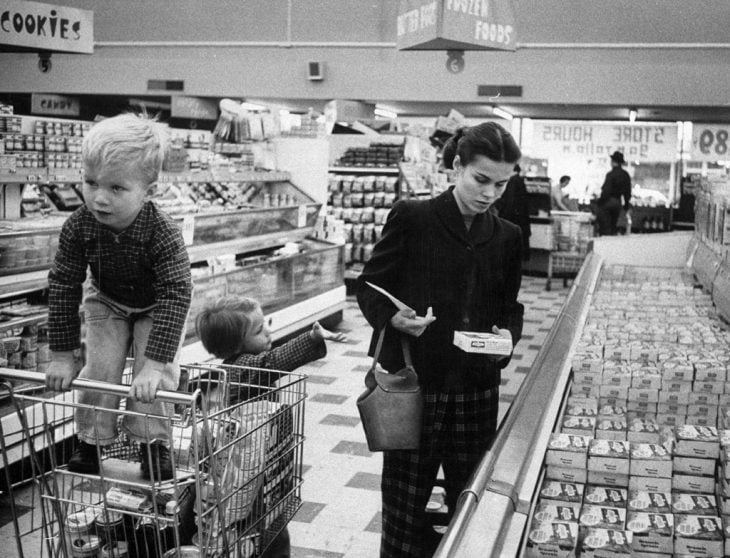 Una madre trabajadora haciendo las compras junto a sus hijos, 1956