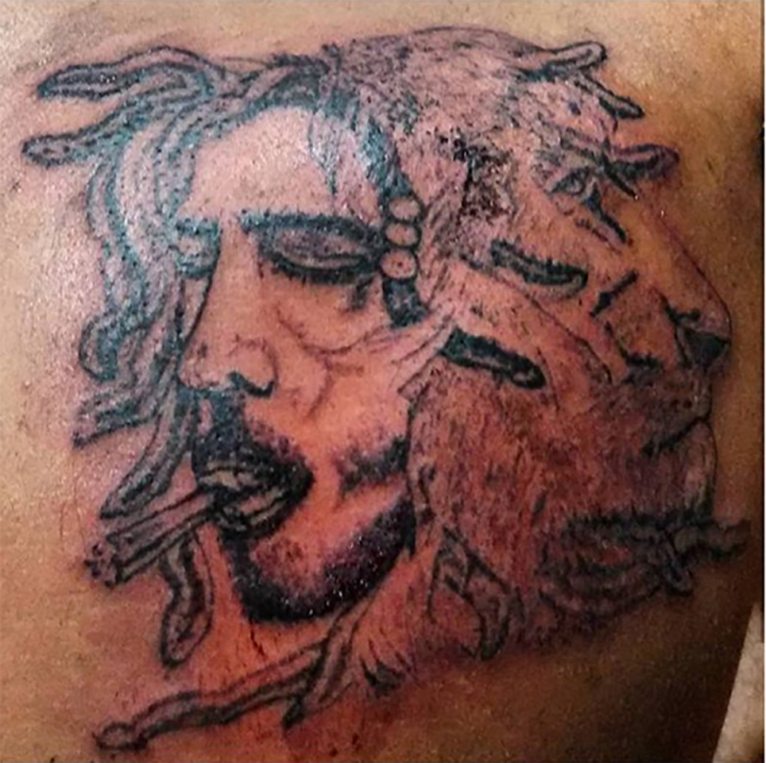 tatuaje mal hehco de hombre con pelo largo