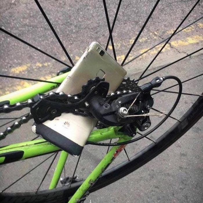 celular atorado en los rines de una llanta de bicicleta