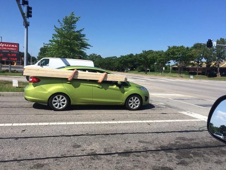 hombres cargando madera en un auto