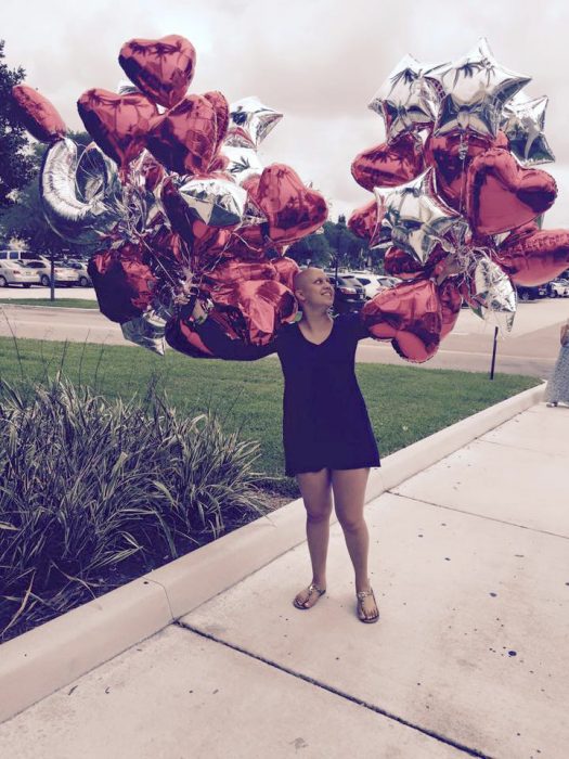 muchacha con muchos globos de corazones