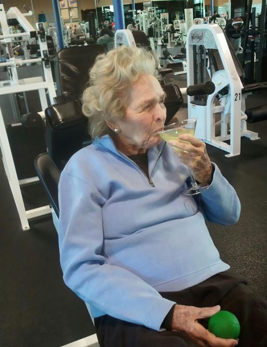 anciana tomando una copa de vino en gimnasio 