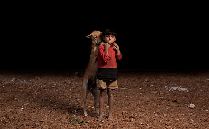 niña de pie con su perro 