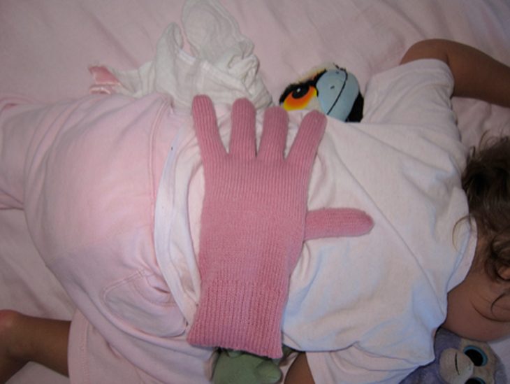 bebé con guante en la espalda 