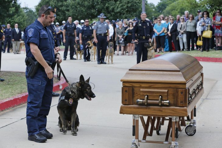 policía y k9 frente a un féretro 