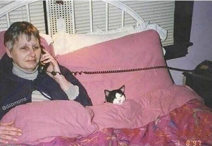 mujer en la cama con su gato 