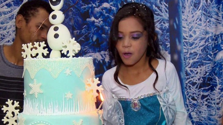 niña soplando las velas de su pastel 