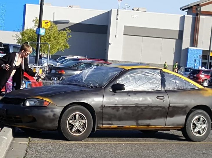 mujer pintando su auto con aerosol 
