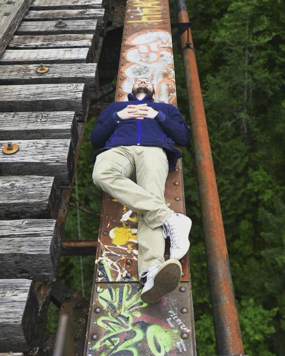 hombre recostado en un puente 