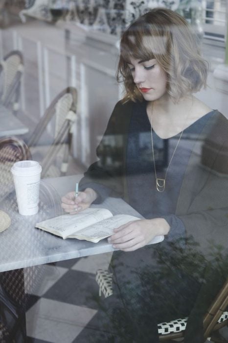 mujer escribiendo en un café 