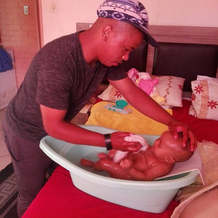 hombre bañando a su bebé 