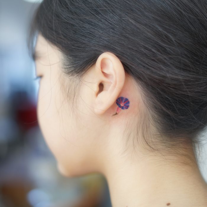 tatuaje de flor detrás de la oreja 