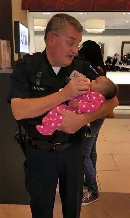 policía alimentando a bebé