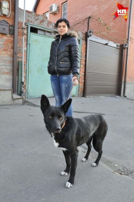 mujer alta y perro negro 